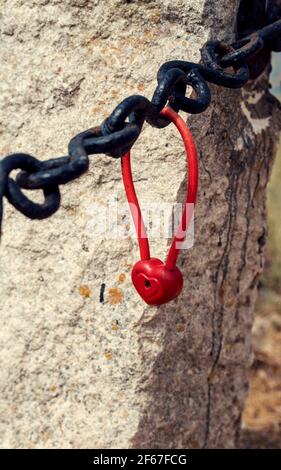 Red padlock heart shaped on a black chain symbol of love and fidelity Vertical image Stock Photo