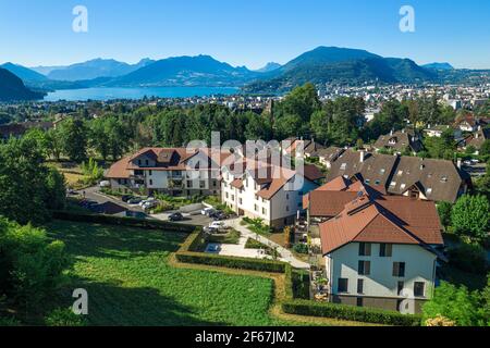 Complex of houses with mountains and large lake in distance. Aerial view of residential real estate in Annecy, France Stock Photo