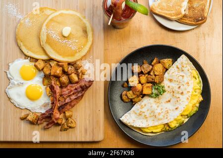Huevos Rancheros and a Slam Breakfast.  Three scrambled eggs in a flour tortilla with refried beans, guacamole and shredded cheese.  Two eggs sunny si Stock Photo
