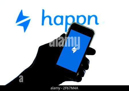 In this photo illustration, the Happn app seen displayed on a smartphone screen and a Happn logo in the background. Stock Photo