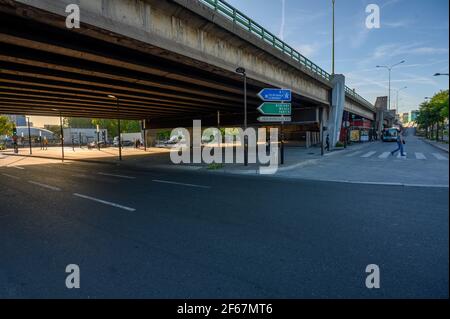 Low angle view of crossroad next to wide concrete highway bridge. Transport infrastructure, road engineering concept. Stock Photo