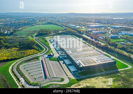 Aerial view of brand new warehouse building in logistic areal. Transport and logistics, modern industrial building and technology. Stock Photo