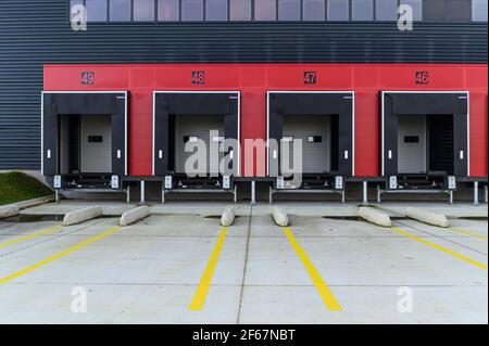 View on four empty loading bays for loading/unloading goods or material. Transport and logistics, modern industrial building and technology. Stock Photo