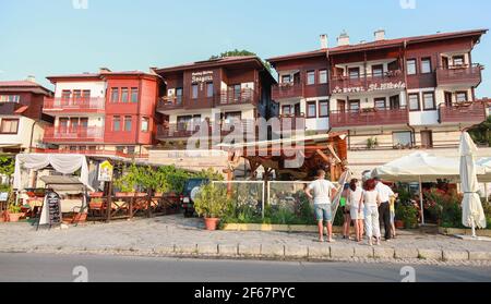 Nessebar, Bulgaria - July 20, 2014: Old town street view with wooden houses. Tourists are on the street near restaurant entrance Stock Photo