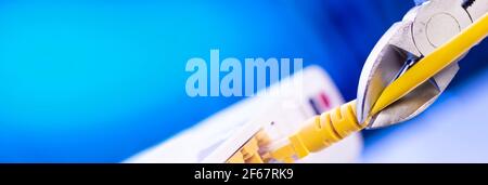 A cutter for cutting a network cable cuts a cable close-up. Stock Photo