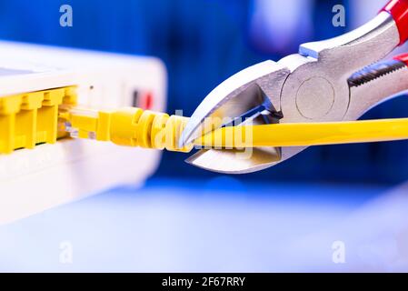 A cutter for cutting a network cable cuts a cable close-up. Stock Photo