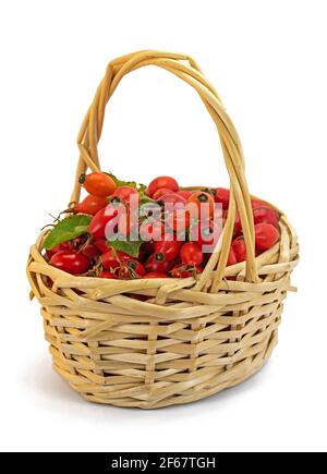 Ripe harvested rose hips in basket against white background Stock Photo