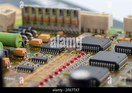 Close-up of electronic circuit board PCB with microchip, processor, integrated circuits, resistances and electronic connections. Stock Photo
