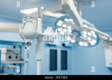 A dropper with medication in the operating room against the background of medical equipment. Selective focus. Stock Photo