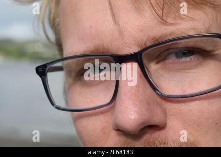 Closeup of Young Man in Glasses Looking at the Camera Stock Photo