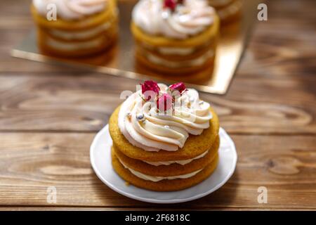 Sponge cake with cream, decorated with small flowers. The concept of a festive treat. Stock Photo