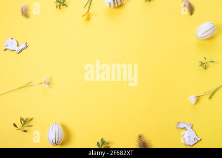 Festive Easter border, frame from easter eggs and spring flower crocus on yellow background. Stylish easter flat lay yellow Stock Photo