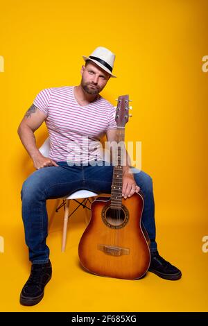 Smiling bearded musician man having fun and playing acoustic guitar.  Stock Photo