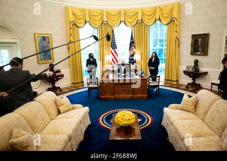United States President Joe Biden makes remarks prior to signing the PPP Extension Act of 2021 into law in the Oval Office of the White House in Washington, DC, Tuesday, March, 30 2021. Standing at left is US Vice President Kamala Harris and at right is Isabel Guzman, Administrator, US Small Business Administration (SBA)Credit: Doug Mills/Pool via CNP | usage worldwide Stock Photo