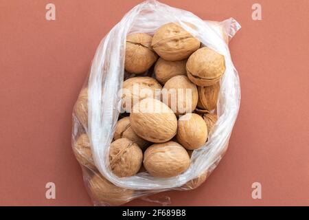 Group of walnuts on brown background in a plastic bag Stock Photo