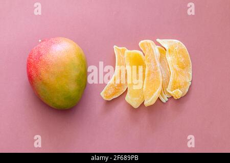 Fresh mango and dry fruit isolated on brown and yellow color blocking background Stock Photo