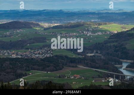 Landscape view of the town of Hauteville, with the lake of Gruyere in the foreground and mountains in the background. Shot Near Fribourg, Switzerland Stock Photo