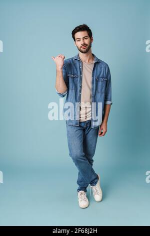 Young handsome guy pointing finger aside at copyspace isolated over blue background Stock Photo