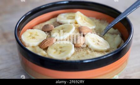 Almonds and banana with in a bowl of cornmeal porridge Stock Photo