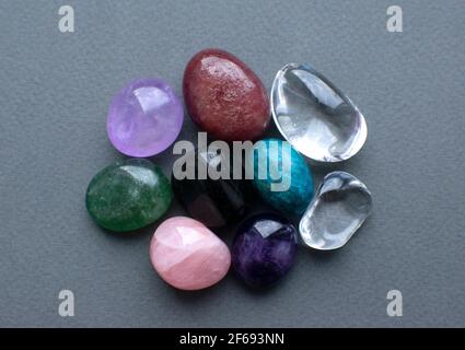 Tumbled gems of various colors. Amethyst, rose quartz, agate, apatite, aventurine, rock crystal. Stock Photo