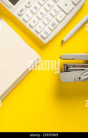 Mock up office accessories on yellow background flat lay of business gadgets calculator pen and notepad Stock Photo