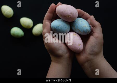 Easter eggs in hands on a dark background, free space Stock Photo