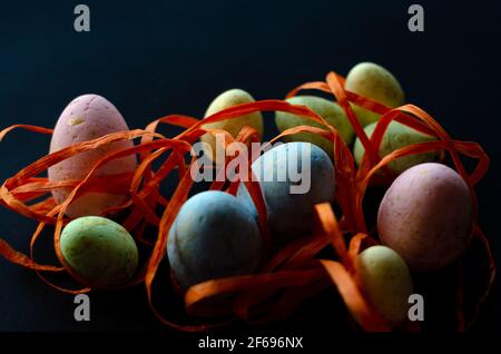 easter eggs in orange ribbon on black background Stock Photo
