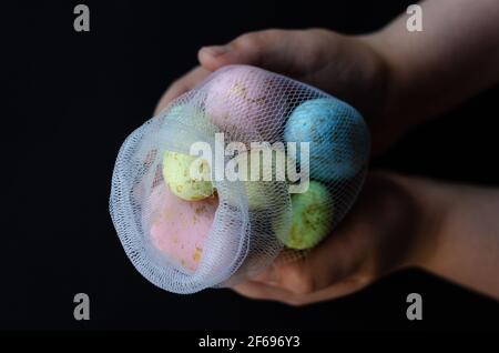 Easter colored eggs in a net, in hand, free space Stock Photo
