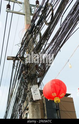 Chaotic, messy cables on a pole in Phuket, Thailand. Stock Photo