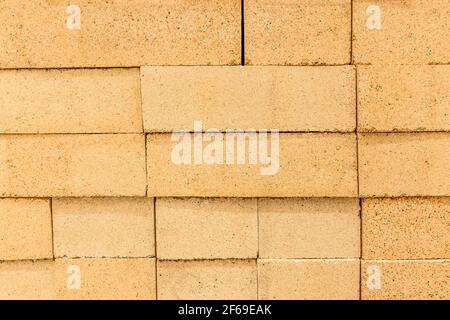 Texture of refractory sand-colored brick blocks wall closeup, background. Stock Photo