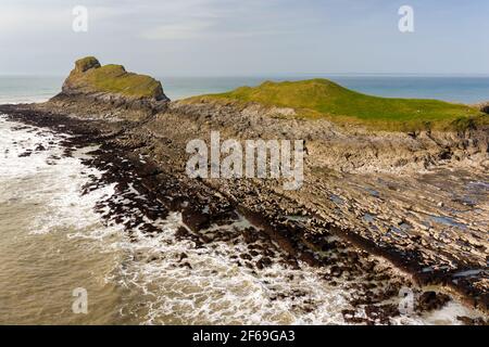 Aerial view of a spectacular rocky coastline and archway at low tide (Worm's Head, Wales) Stock Photo