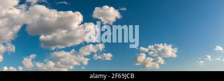 Deep blue sky with rare clouds lit with sunlight Stock Photo