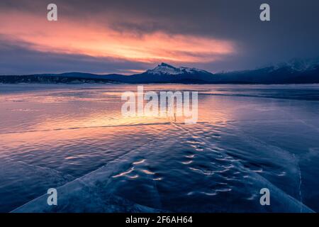Frozen lake with cracks on Abraham Lake, Alberta, Canada Stock Photo