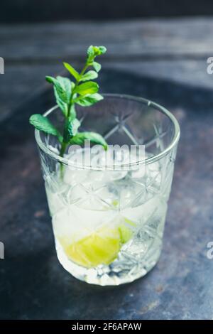 Old fashioned beverage with lime and mint leaves. Selective focus. Shallow depth of field. Stock Photo