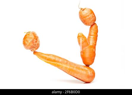 Fresh natural ugly raw carrots isolated on white background. Balancing carrots, healthy nutrition concept Stock Photo