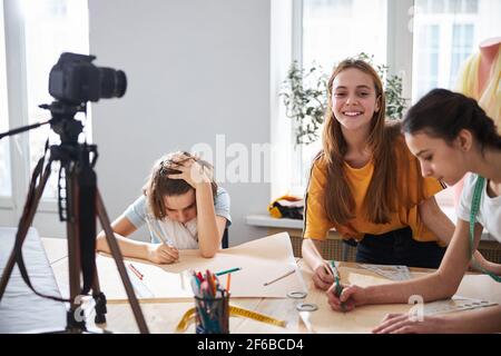 Cheerful kids recording video for sewing blog in workshop Stock Photo