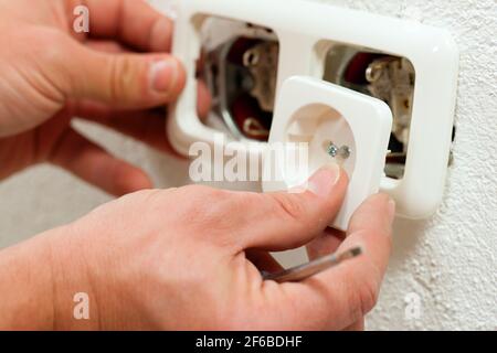Electrician installing a power socket, close-up Stock Photo