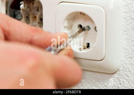 Electrician installing a power socket, close-up Stock Photo