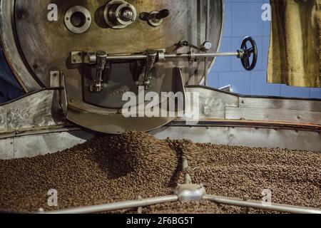 Coffee being mixed in a coffee roasting machine. Mixing coffee. Stock Photo