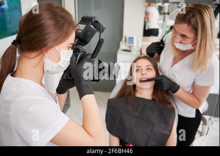 Dentist taking picture of female patient in dental office. Stock Photo