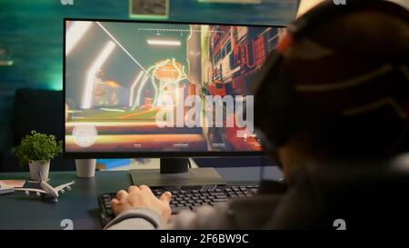 Back of pro gamer playing first person shooter video game on professional  computer for cyber esport competition. Pro player talking with multiple  players using headset during online tournament Stock Photo - Alamy