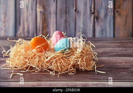 Easter eggs in straw on wooden background Stock Photo