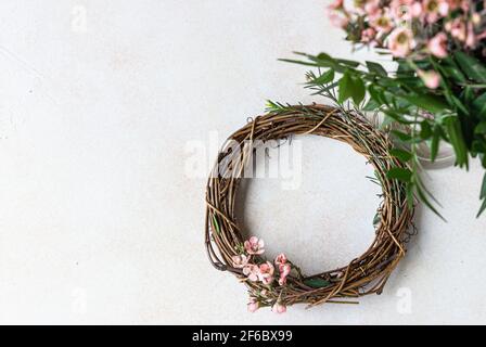Decorative spring wreath made of twigs and flowers. DIY creativity. Top view. Copy space. Selective focus. Stock Photo