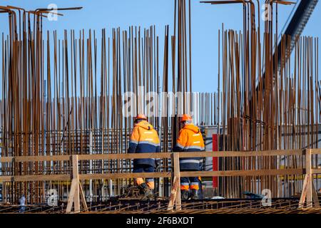 Unrecognizable builders walking on construction site Stock Photo