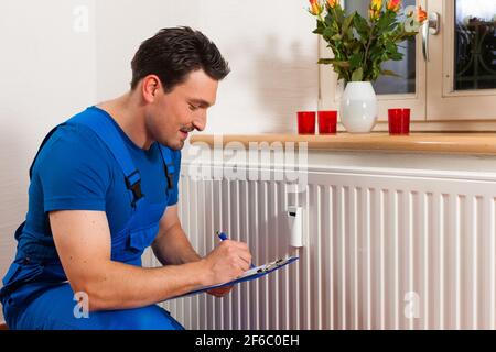 Technician reading the heat meter to check consumption Stock Photo