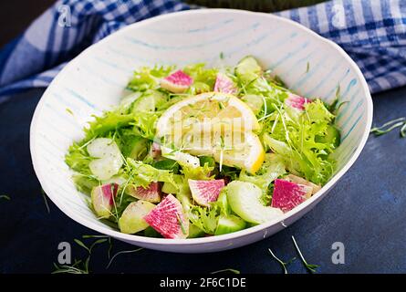 Salad from watermelon radish, cucumber, celery and lettuce leaves. Vegan food. Dietary menu. Stock Photo