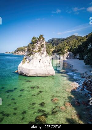 Big sea stack standing at sandy beach in Cathedral Cove area. Aerial view of New Zealand fantastic landscapes and scenery. Stock Photo