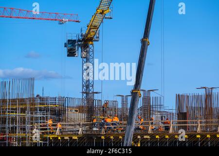 Builders walking on bridge near unfinished building Stock Photo