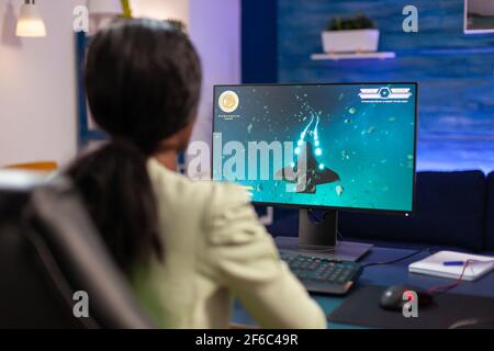 Man gamer teaching his girlfriend playing space shooter video game on RGB  powerful personal computer. Pro cyber woman with headset performing video  games streaming from home during online tournament Stock Photo 