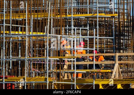 Unrecognizable builders walking on construction site Stock Photo